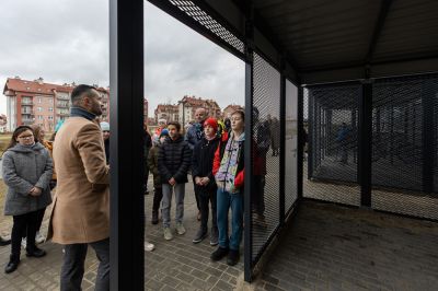 Prezydent Konrad Fijołek i młodzież przy zadaszonych wiatach na jednoślady, wybudowanych obok SP nr 18, fot. Grzegorz Bukała/UM Rzeszowa