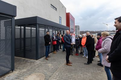 Prezydent Konrad Fijołek i młodzież przy zadaszonych wiatach na jednoślady, wybudowanych obok SP nr 18, fot. Grzegorz Bukała/UM Rzeszowa